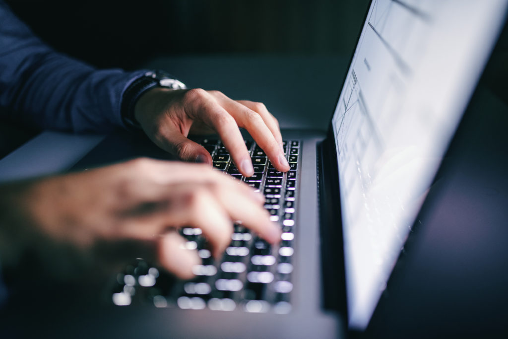 A person types on a laptop